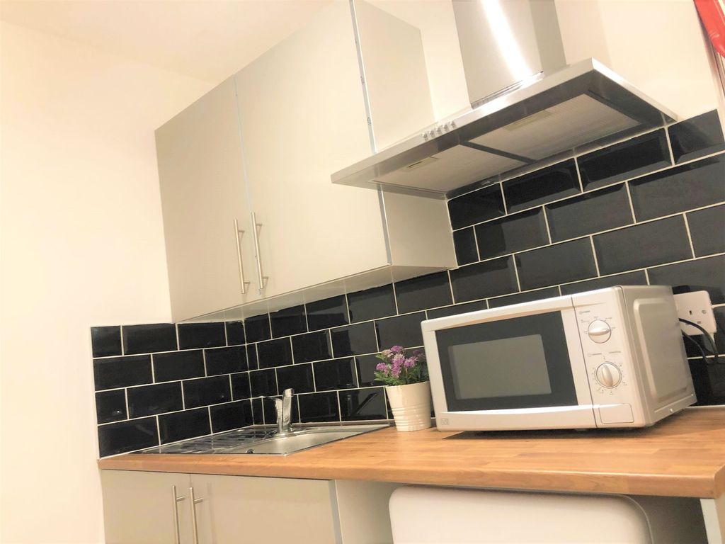 Property photo 3 of 7 A Modern Kitchen Featuring Sleek Black Tiled Backs...