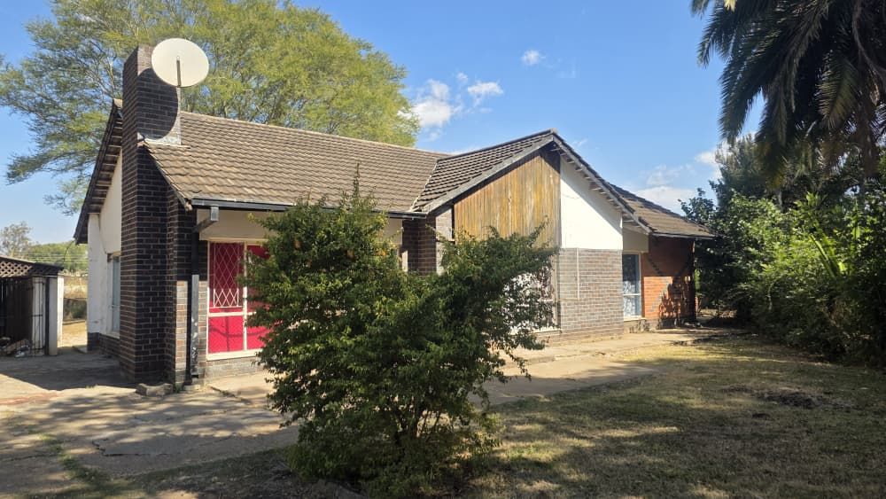 Property photo 1 of 12 Single-Story Brick And Stucco House With Red Front Doors, A Satellite Dish, And A Yard With Trees