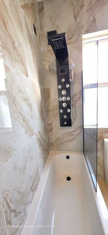 Property photo 3 of 9 Modern Bathroom Featuring A Sleek Shower Panel Wit...