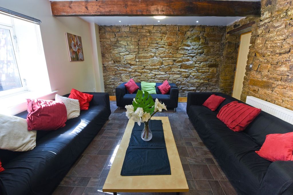 Property photo 3 of 17 A Cozy Living Room Featuring Exposed Stone Walls A...