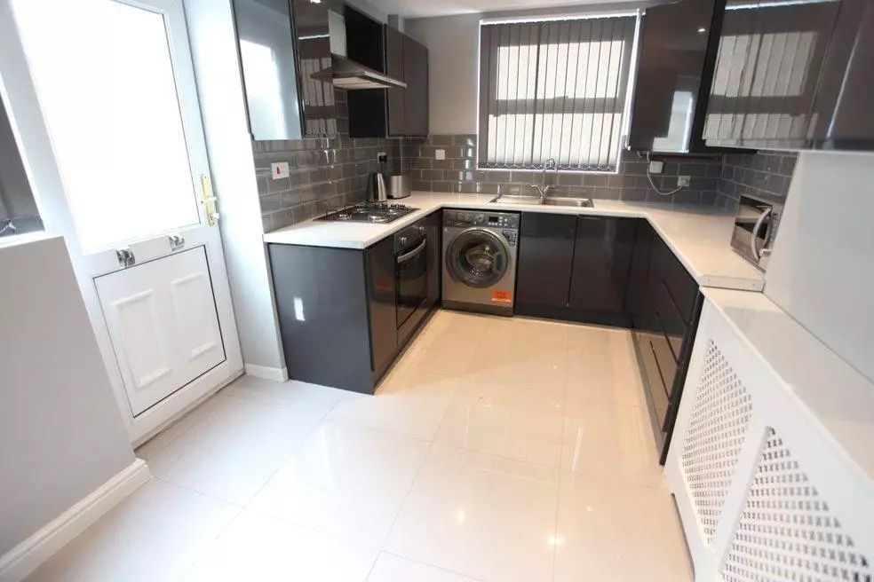Property photo 3 of 8 Modern Kitchen Featuring Sleek Dark Cabinetry, A B...