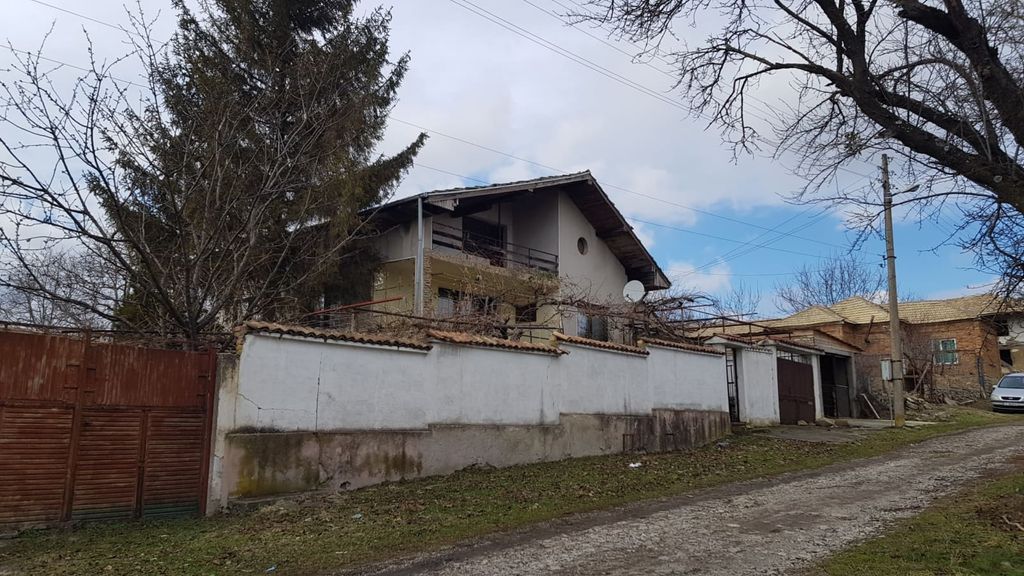 Property photo 1 of 100 View Of A Two-Storey House With Balcony And Sloped Roof Behind A White Garden Wall And Wooden Gate