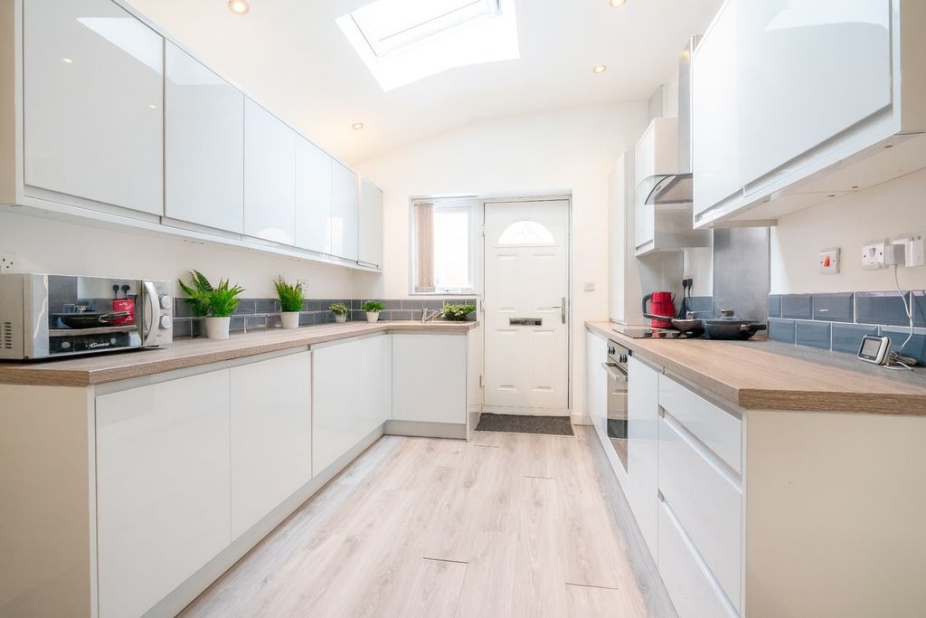 Property photo 2 of 8 Bright And Modern Kitchen Featuring Sleek White Ca...