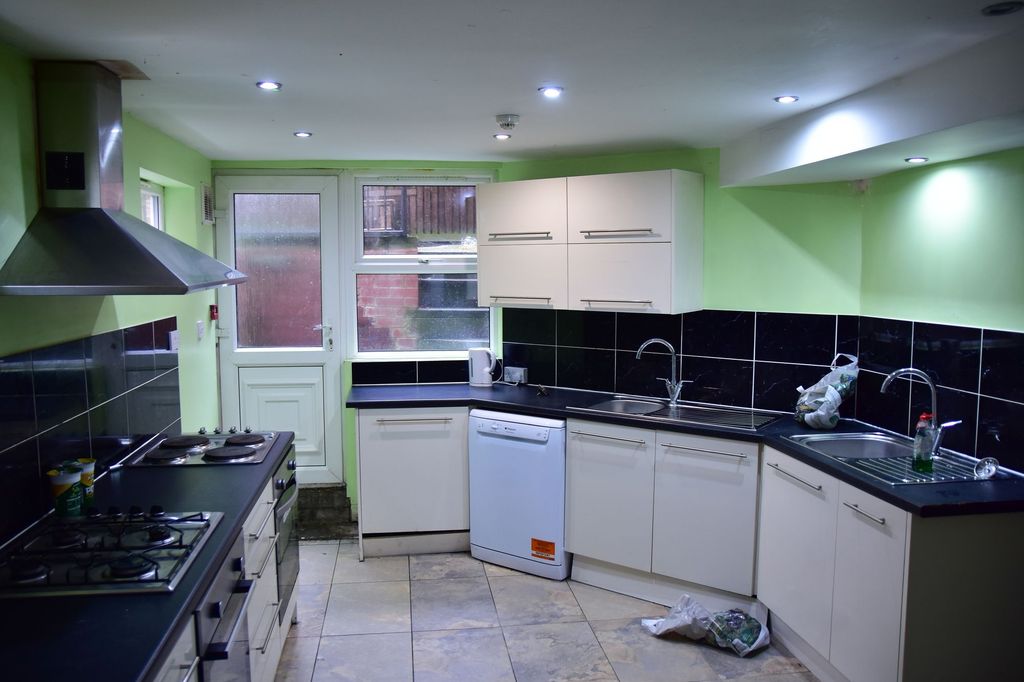 Property photo 3 of 8 A Practical Kitchen Featuring White Cabinetry, Bla...
