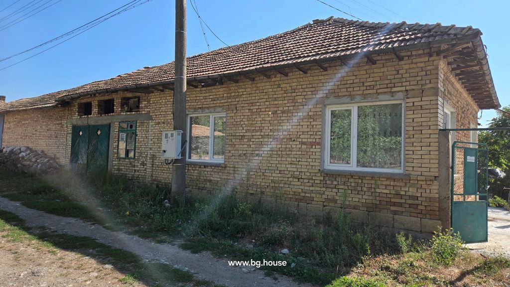 Property photo 3 of 41 Brick House Side View Showing Green Double Doors, Windows, Utility Pole, And Surrounding Vegetation