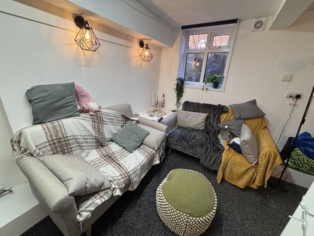 Property photo 1 of 18 A Cozy And Well-Lit Living Room Featuring Comforta...