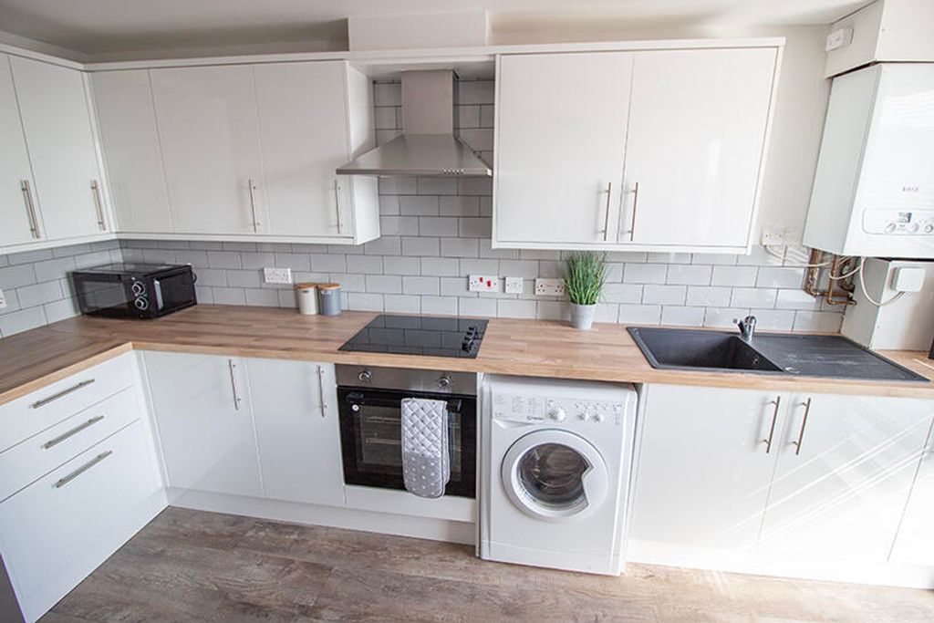 Property photo 2 of 9 Modern Kitchen Featuring Sleek White Cabinetry, Am...