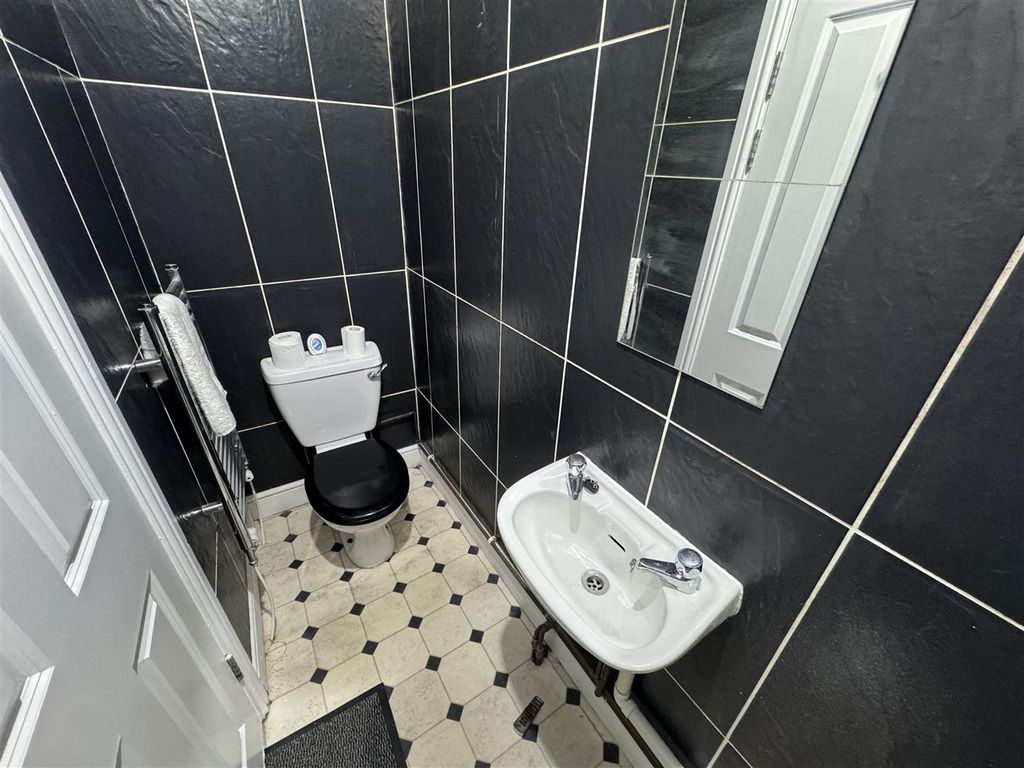 Property photo 3 of 14 Modern Tiled Washroom With Sleek Dark Finishes...