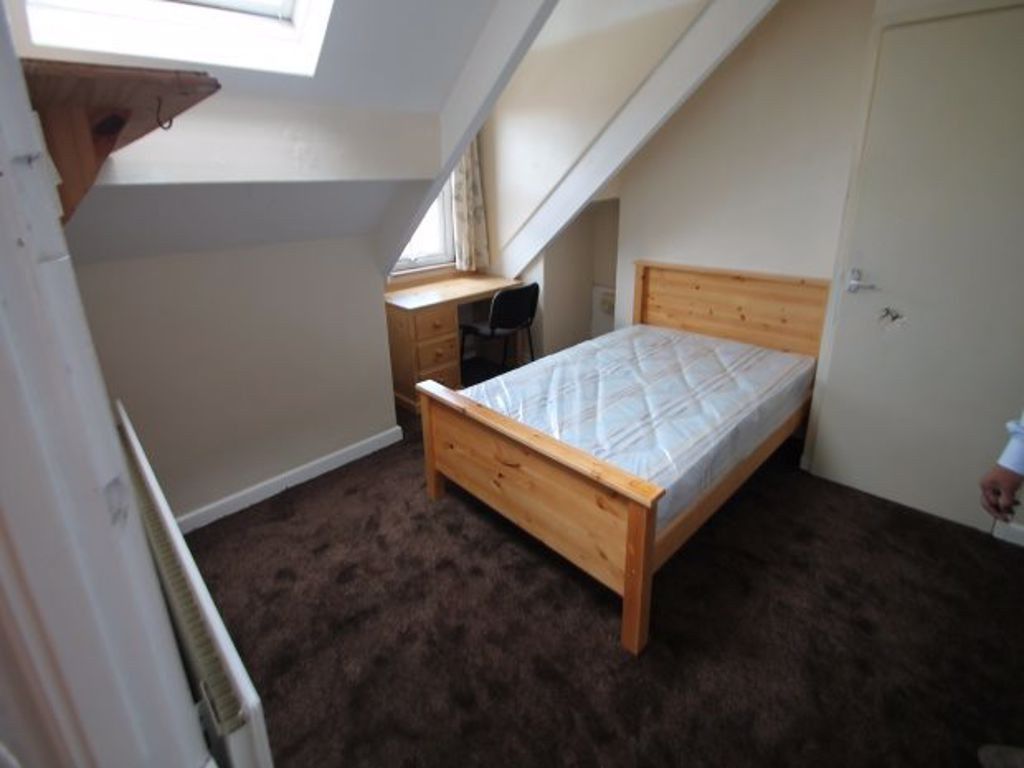 Property photo 2 of 13 A Cozy, Well-Lit Bedroom Featuring A Wooden Bed Fr...