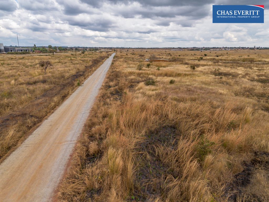 Property photo 2 of 10 Dirt Road Winds Through Dry Grassland Toward Distant Buildings On A Cloudy Day; Chas Everitt Logo In The Upper-Right Corner.