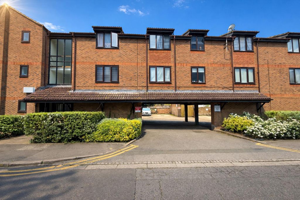 Property photo 1 of 6 Red Brick Building With Flowering Bushes.Png