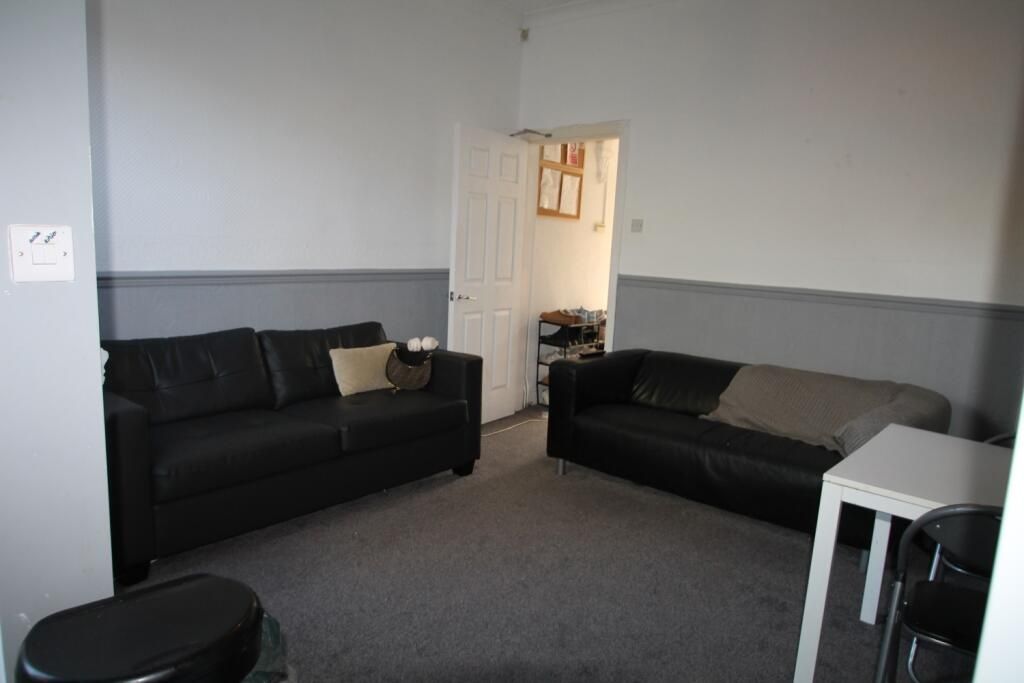 Property photo 3 of 7 A Cozy Living Room Featuring Two Black Sofas Facin...