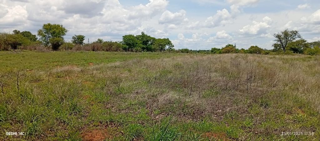 Property photo 1 of 9 Open Grassy Field With Scattered Shrubs And A Tree Line On The Horizon Under A Cloudy Sky, Daytime Scene.