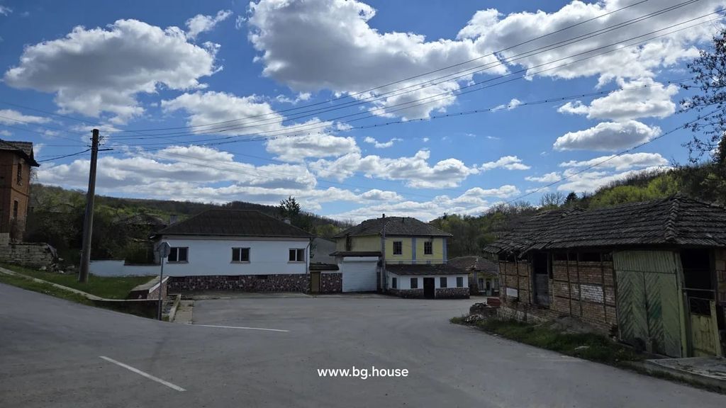 Property photo 2 of 40 Wide Shot Showing A White House With Stone Base And Adjacent Yellow Building, With Rural Road And Power Lines Overhead.