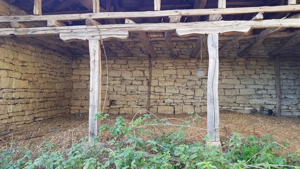 Property photo 2 of 50 Exterior View Of A Stone Outbuilding Featuring Wooden Beams And An Open Side, With Green Plants Growing Nearby.