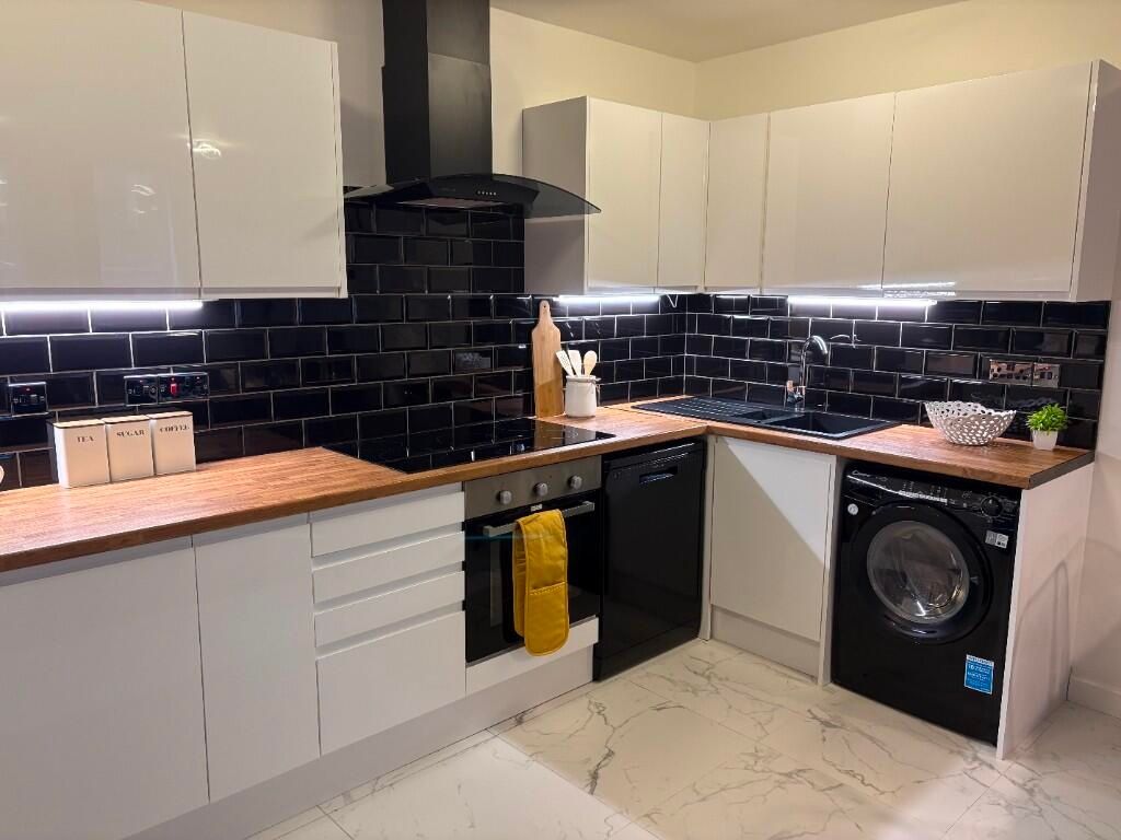 Property photo 3 of 15 Modern Kitchen With Sleek White Cabinets, Wood-Eff...