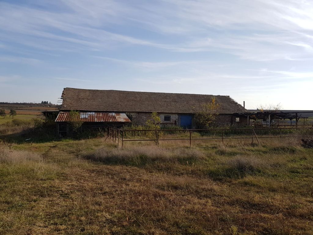Property photo 1 of 33 View Of The Long Farm Building With A Tiled Roof And Metal Fencing In Front, Surrounded By Dry Grass And Open Countryside.