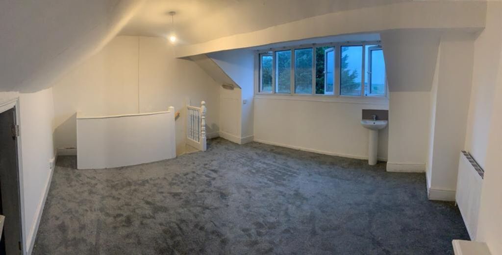 Property photo 2 of 12 Spacious And Bright Living Room Featuring Large Wi...