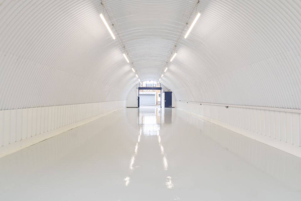Property photo 2 of 4 An Empty Arch With White Lining, Facing The Front Electric Roller Shutter Entrance, Which Is Closed. There Is A WC Cubicle At The Front Of The Arch.