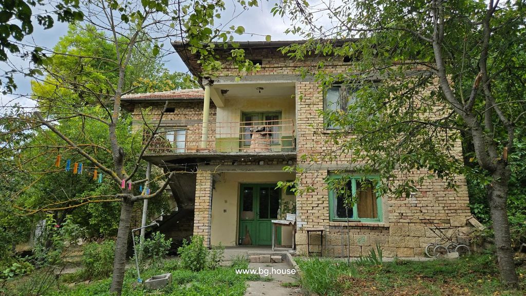 Property photo 1 of 53 Two-Story Brick House With Green Doors And Windows, Surrounded By Trees And Garden With Clothesline And Clothespins.