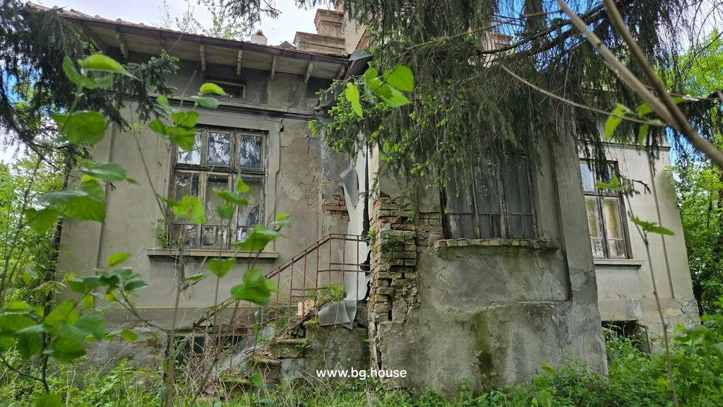 Property photo 1 of 48 View Of An Old House Showing Cracked Walls, Broken Windows, And Overgrown Vegetation Around It