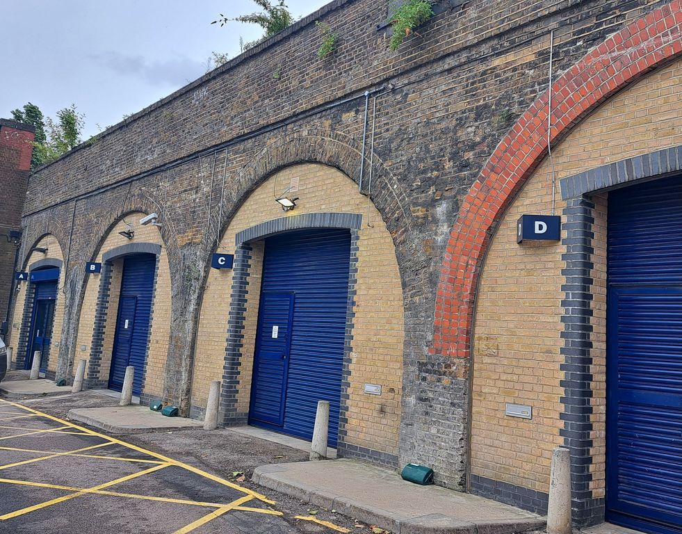 Property photo 1 of 1 An Estate, With Multiple Arches Next To Each Other. The Arches Have Closed Electric Roller Shutter Entrances.