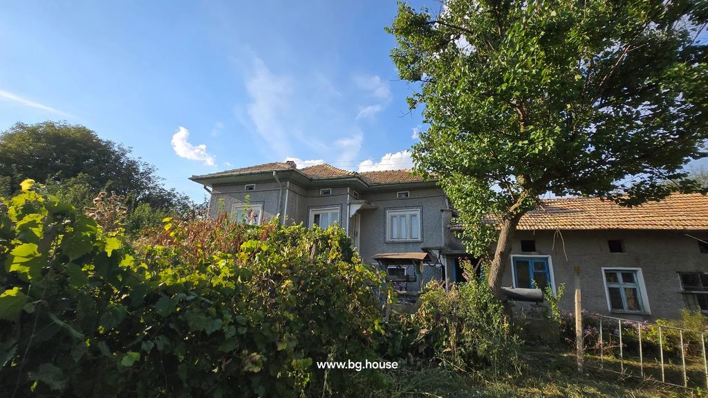 Property photo 2 of 64 Two-Story House With Gray Walls And Tiled Roof, Surrounded By Greenery And A Tree In Front, Under Blue Sky.
