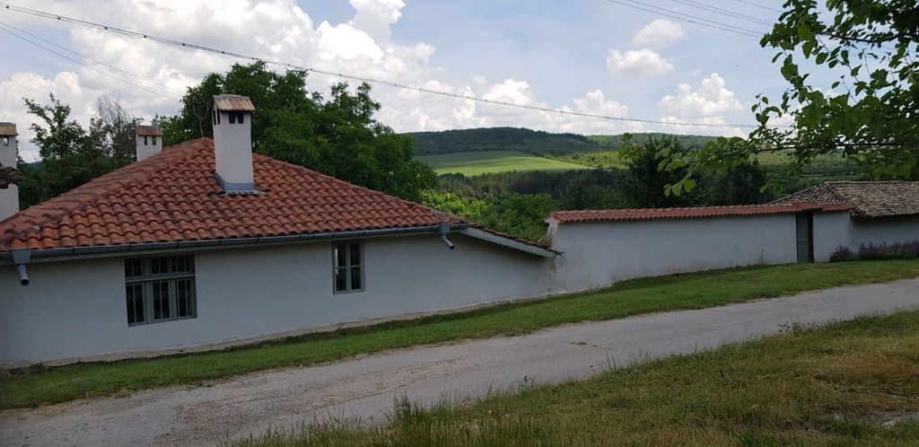 Property photo 1 of 100 White House With Terracotta Tiled Roof And Chimney Set Against Green Hills And Cloudy Sky