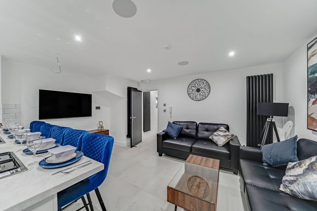 Property photo 1 of 5 Modern And Spacious Living Room Featuring Sleek Bl...