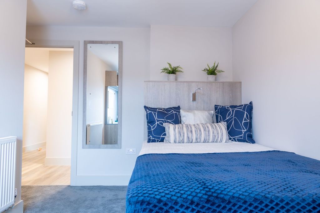 Property photo 3 of 12 A Well-Lit, Modern Bedroom Featuring A Neatly Made...