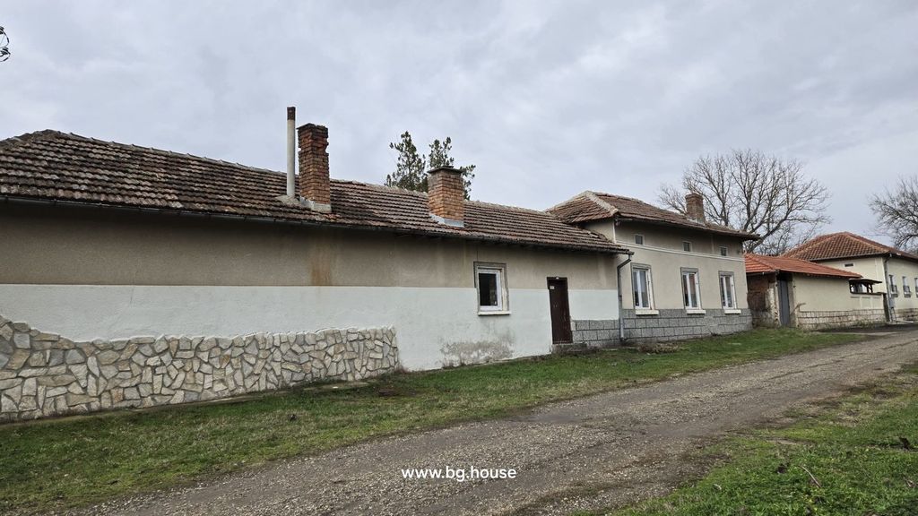 Property photo 2 of 90 Side Facade Of A Bulgarian House Showing Multiple Chimneys, Windows, And A Dirt Road Alongside The Building.