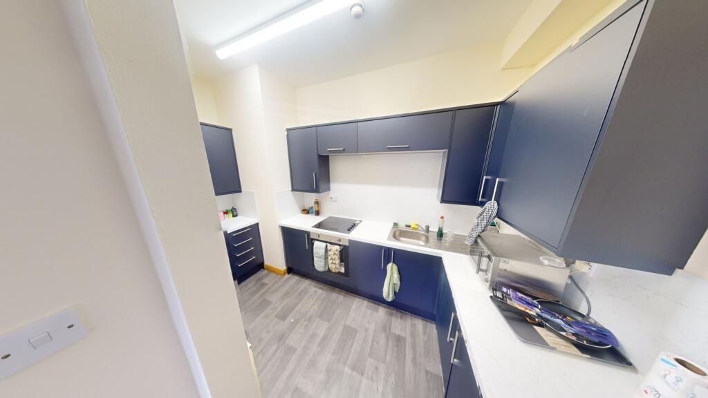 Property photo 3 of 9 A Modern Kitchen With Dark Blue Cabinetry And Whit...
