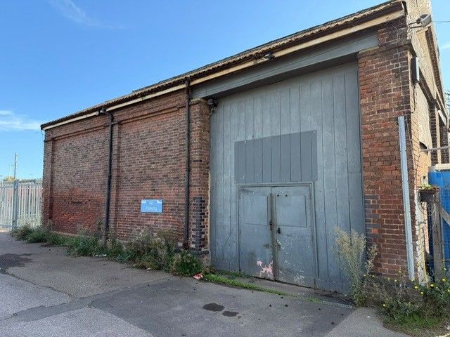 Property photo 1 of 1 The Front Of A Warehouse Unit, With A Closed Electric Roller Shutter Entrance Big Enough For Vehicle Access, And A Pedestrian Door.