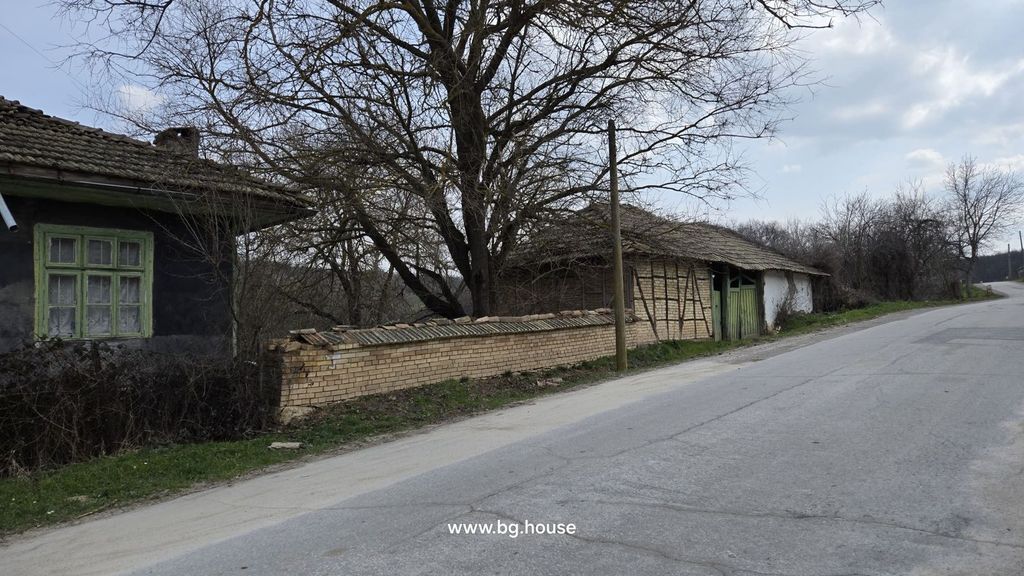 Property photo 2 of 49 Side Perspective Of A Rustic House With Green Window Frames And An Adjacent Brick And Wood Outbuilding Beside A Paved Village Road.