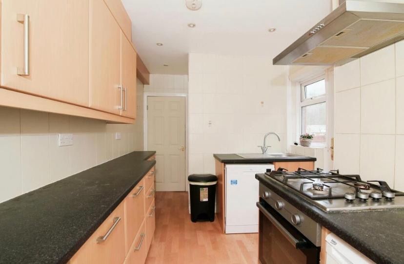 Property photo 2 of 9 Bright Galley-Style Kitchen With Light Wood Cabine...