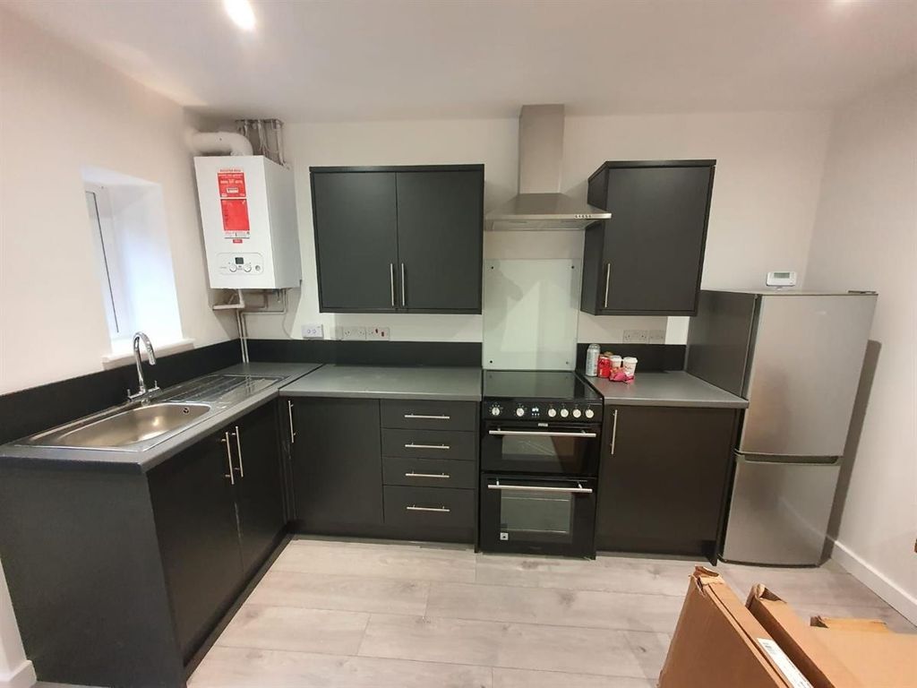 Property photo 3 of 15 Sleek Modern Kitchen With Dark Cabinetry...