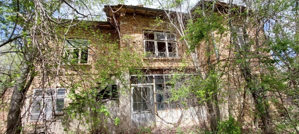 Property photo 2 of 52 Front Facade Of The Brick House With White Framed Windows And Trees In Early Spring
