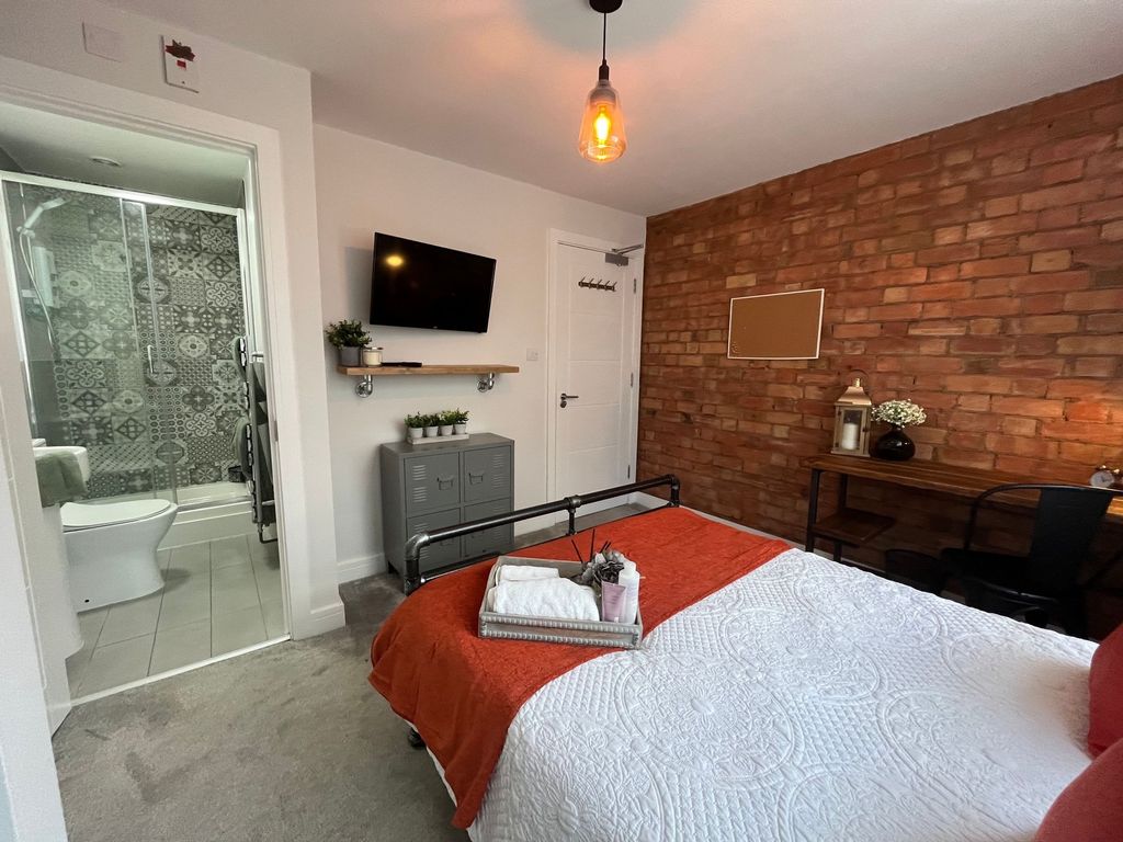 Property photo 3 of 7 A Stylish And Inviting Bedroom Featuring A Cozy Do...