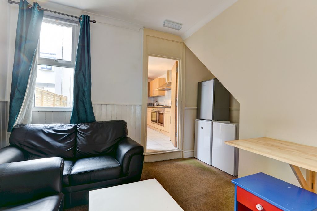 Property photo 3 of 22 A Cozy Living Room With A Black Leather Sofa, A Co...