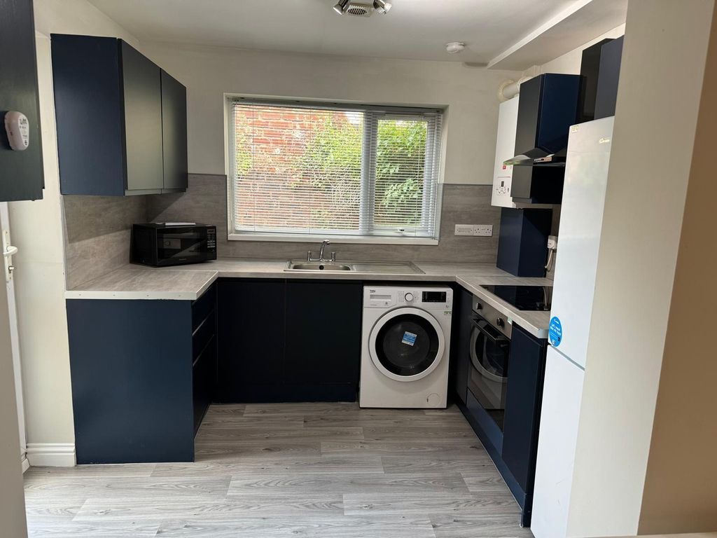 Property photo 3 of 9 A Modern Kitchen Featuring Sleek Navy Cabinetry, A...