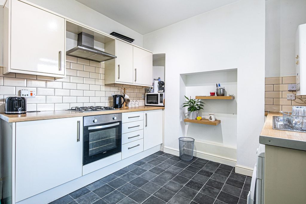 Property photo 1 of 5 Bright And Modern Kitchen Featuring Sleek White Ca...