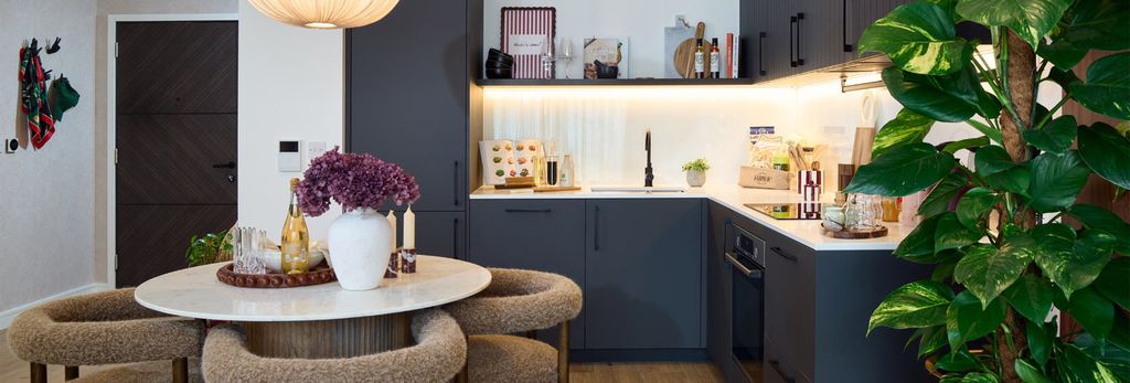Property photo 2 of 4 Kitchen, Navy Blue Cupboard Panels And White Countertops, Modern Appliances, Dining Table In