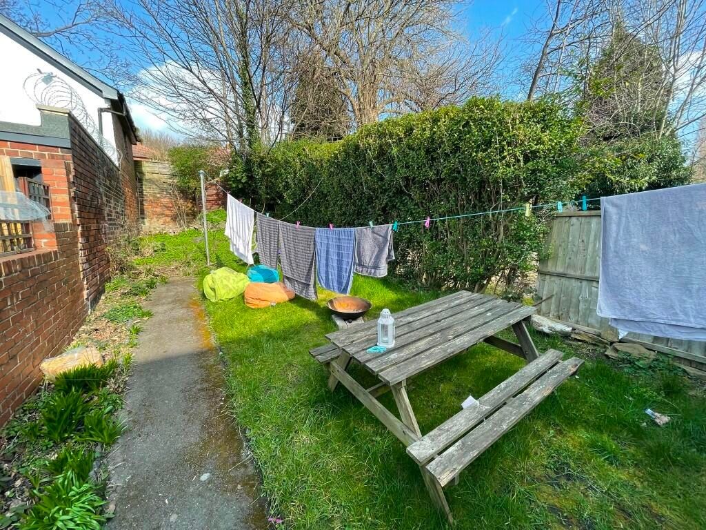 Property photo 1 of 9 A Sunny Garden Area Featuring A Wooden Picnic Benc...