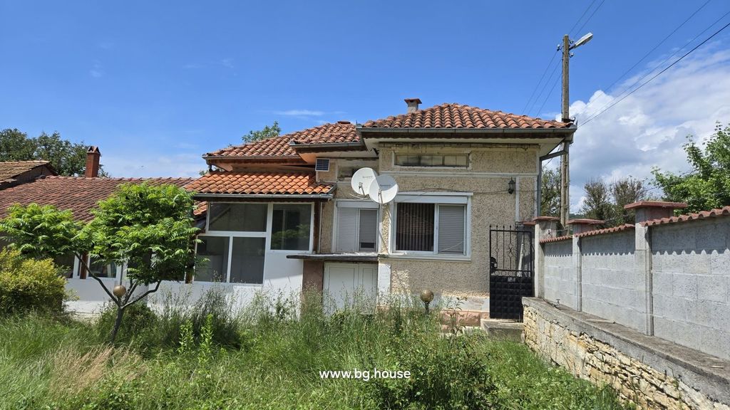 Property photo 1 of 55 Exterior View Of A Bulgarian House With Terracotta Tiled Roof, Satellite Dishes, And A Garden With Green Trees And Grass.