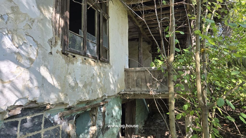 Property photo 3 of 32 Side Perspective Of The House Showing White Plaster Walls, A Wooden Balcony, And Dense Garden Vegetation.