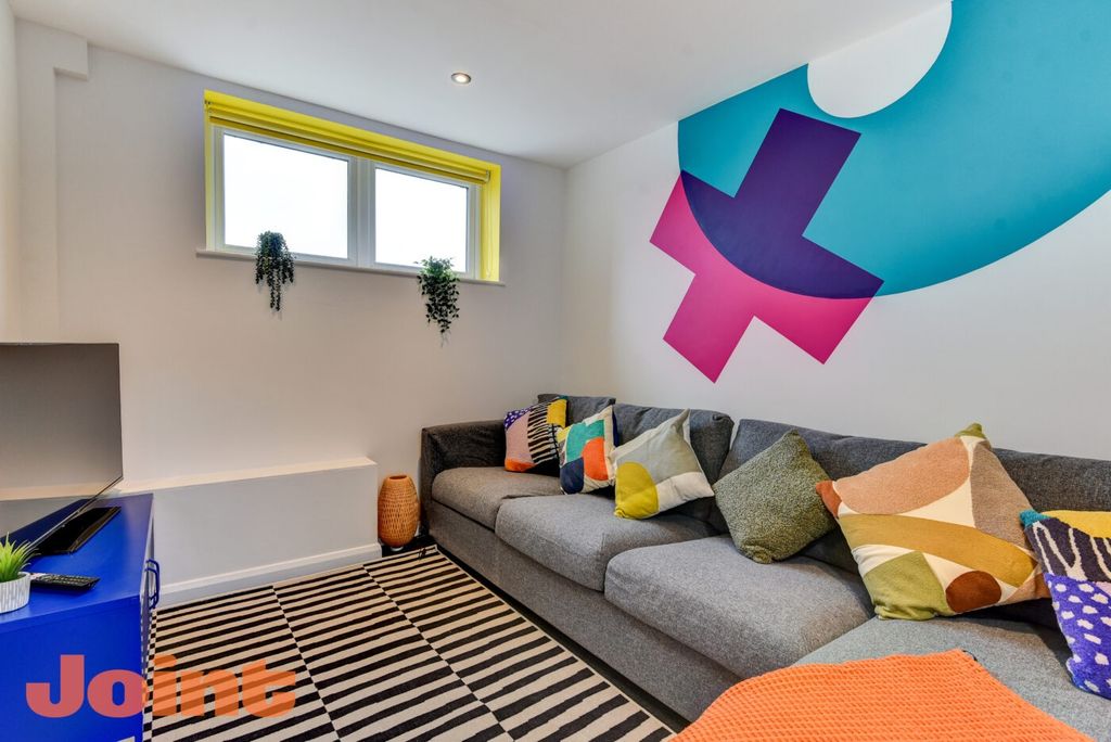 Property photo 1 of 6 Modern And Vibrant Living Room Featuring A Spaciou...