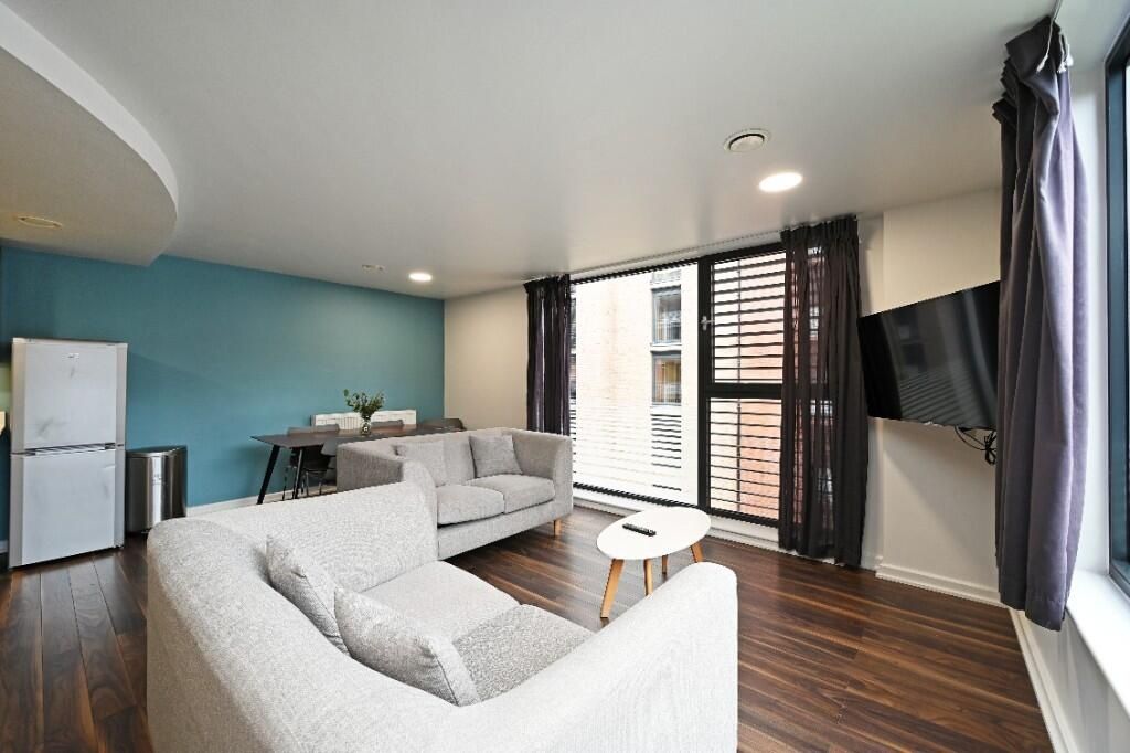 Property photo 2 of 12 Bright And Modern Living Room Featuring Large Wind...