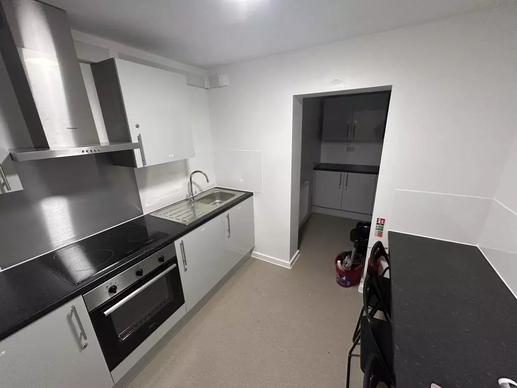 Property photo 3 of 7 Modern Galley Kitchen With Sleek White Cupboards, ...