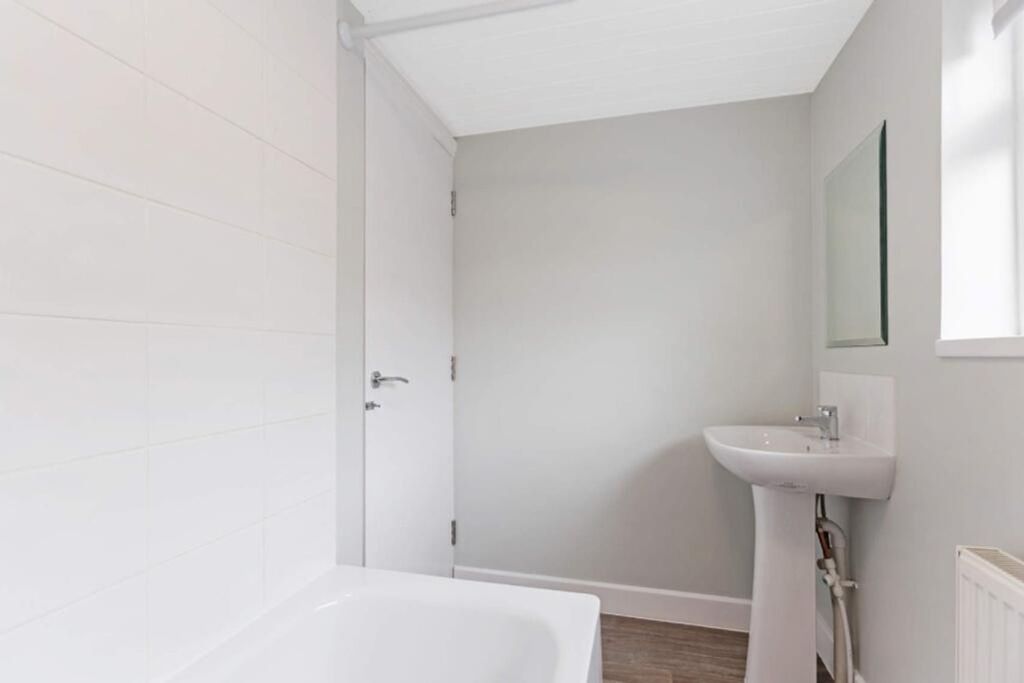 Property photo 3 of 14 A Modern Bathroom Featuring A Sleek Bathtub And A ...