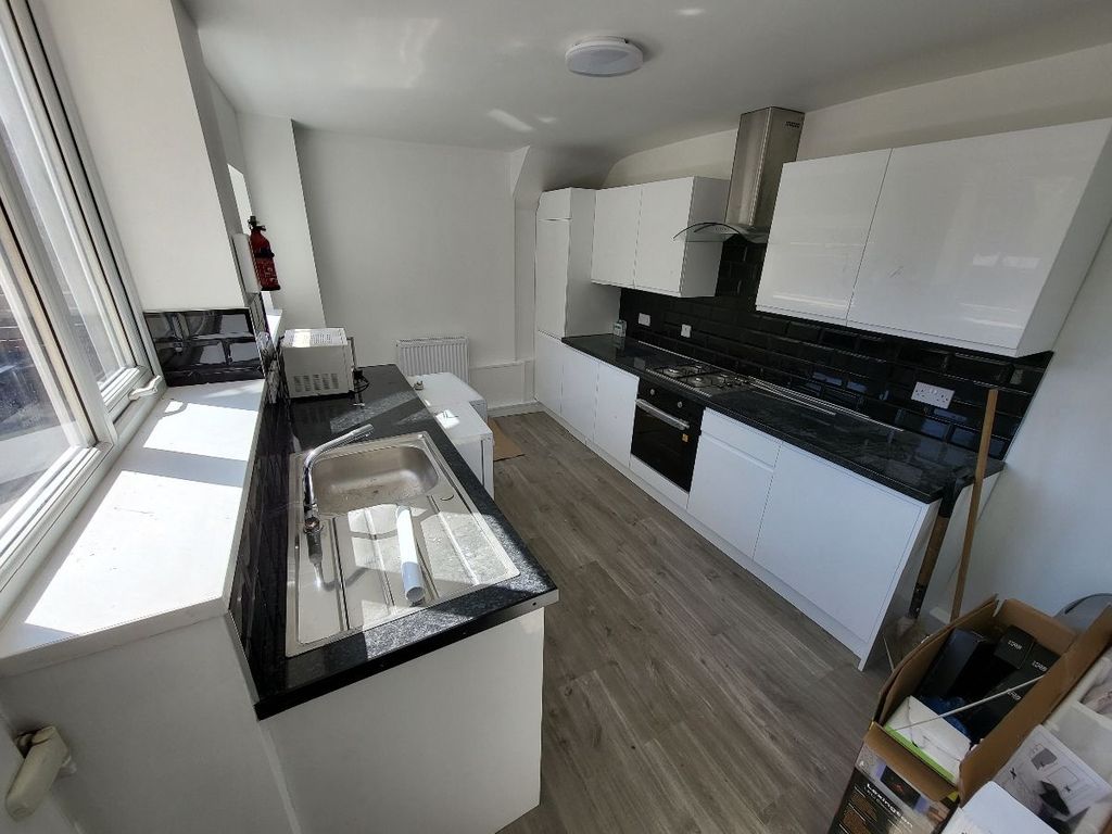 Property photo 3 of 9 This Modern Kitchen Features Sleek White Cabinetry...
